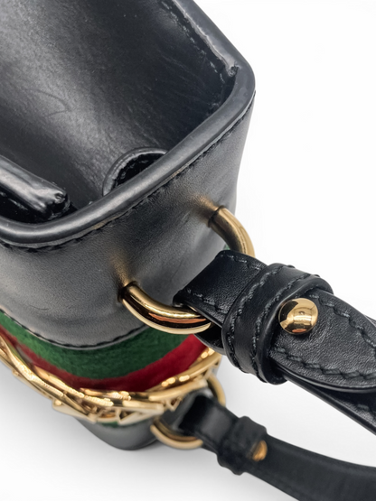 Detailed view of Gucci Sylvie black leather bag hardware, showcasing the top handle connection, gold-tone fittings and iconic web stripe From luxury designer consignment boutique Dee Black, in Perth, Western Australia.