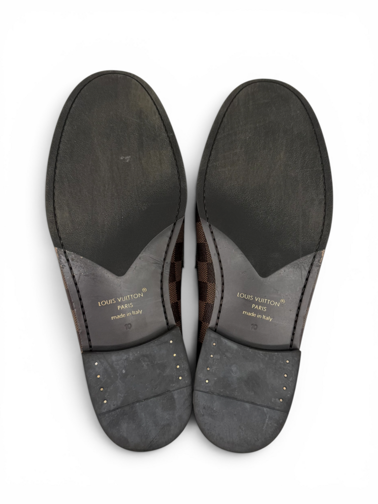 Louis Vuitton men's Damier Ebene loafers with leather outsoles, displayed from underneath with embossed branding details. From designer consignment boutique, Dee Black, in Perth, Western Australia.